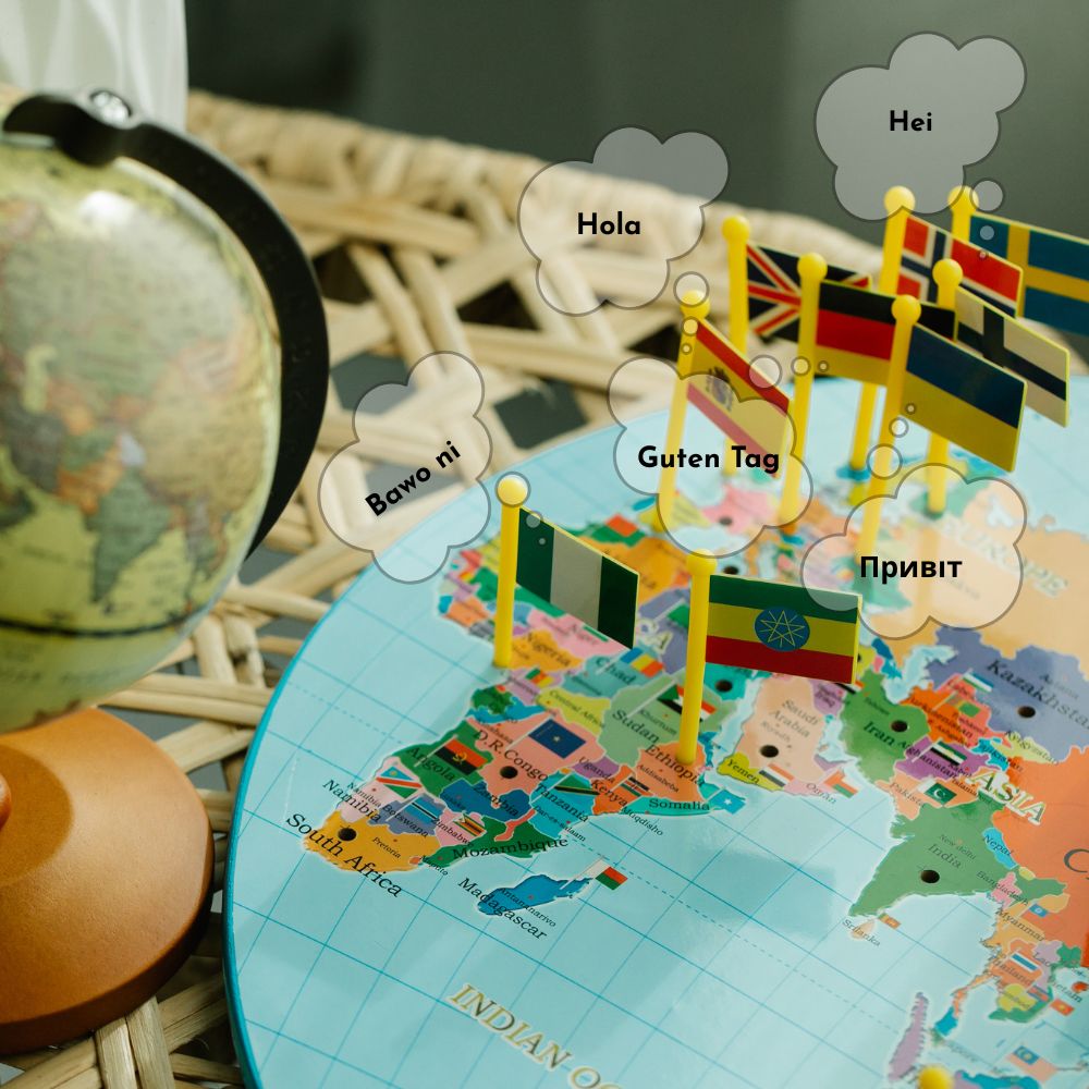 World map with flags and greeting words in different languages, next to a globe.